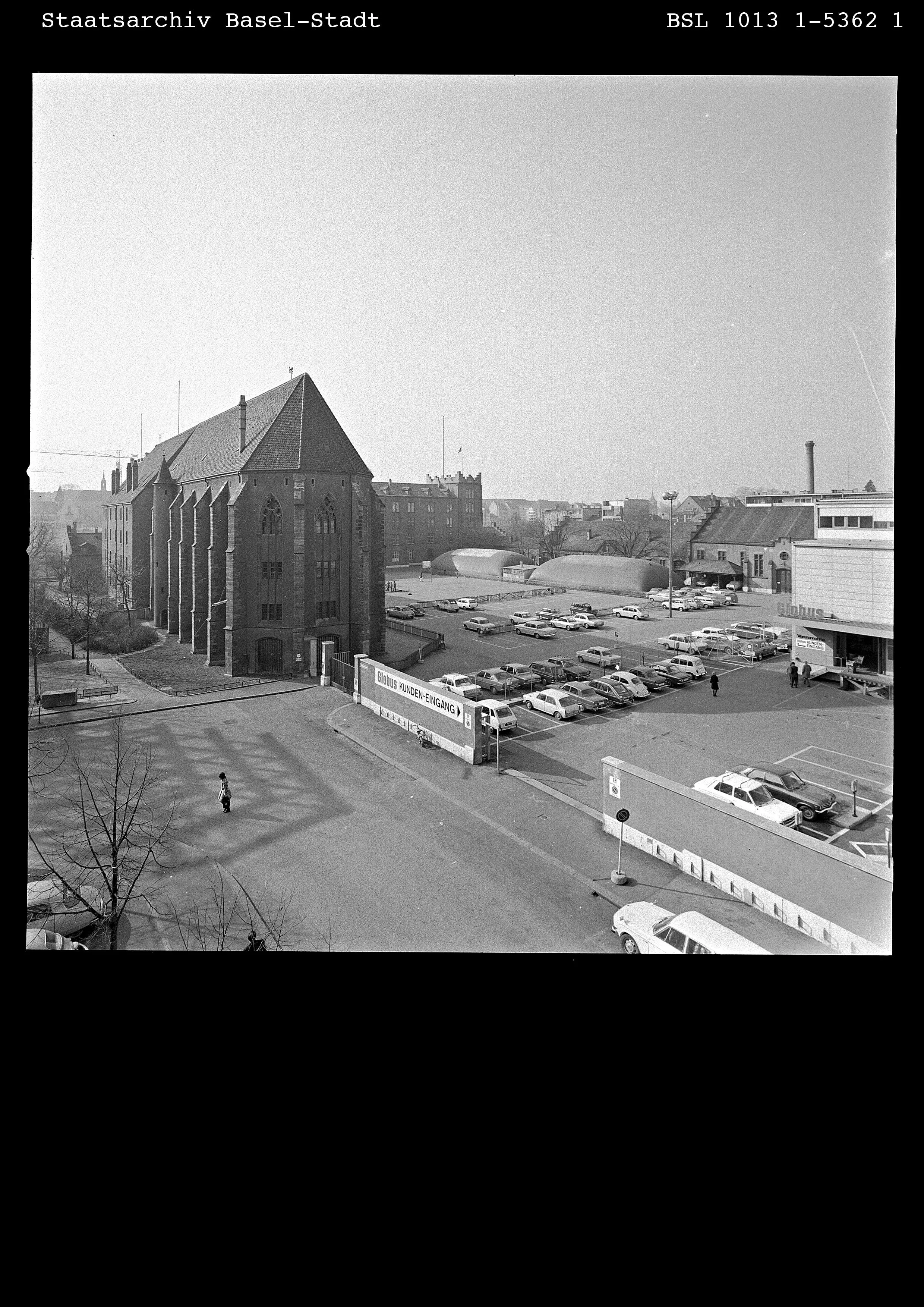 Eine Fotografie, die das Basler Kasernenareal im Jahr 1974 zeigt. Zu sehen sind die Klingental-Kirche, der Hauptbau, geparkte Autos und der Eingang zum Globusprovisorium.